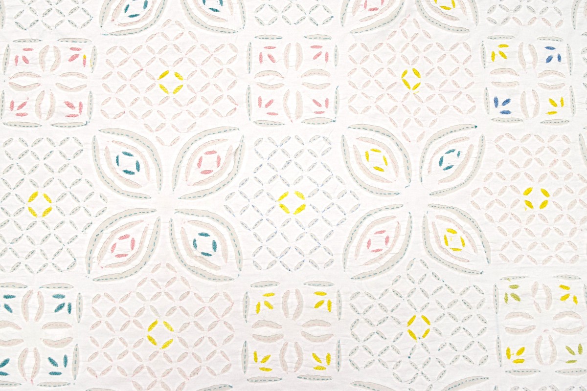 close up view of vintage gujurati bedspread with hand embroidery & cut work