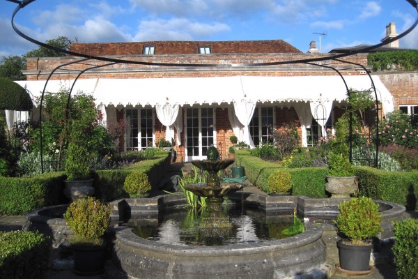 Three Long Pergolas end to end in front of a country house